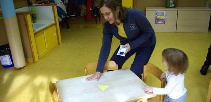 Una educadora del Colegio Pasacalles de Algete (Madrid) limpia una mesa con toallitas impregnadas.