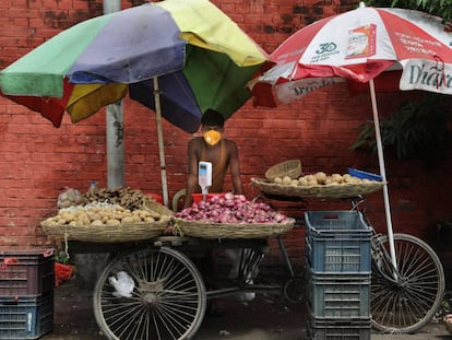 Un vendedor de verduras usa una mascarilla protectora mientras espera a los clientes en Kolkata, India, el 17 de julio de 2020. 