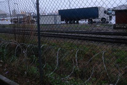 Cola de camiones a la entrada del puerto de Santander, con concertinas pegadas a la valla.