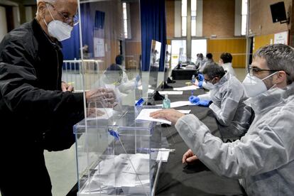 Varios miembros de las mesas electorales con el equipo de protección EPI en el Centro Cívico de Sant Julià de Ramis, en Girona. Las autoridades han pedido respetar las franjas horarias de votación y las primeras horas estaban reservadas para las personas mayores y vulnerables.