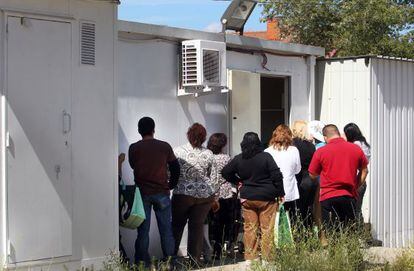 Un grupo de ciudadanos de Tres Cantos, Madrid, hace cola para recoger alimentos en la Cruz Roja.