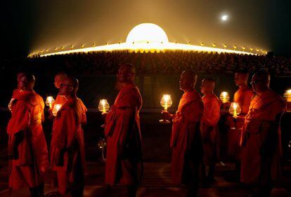 Monjes budistas tailandeses caminan en círculo con velas en celebración del día Magha Puja, en el templo Wat Phra Dhammakaya, en la provincia Pathum Thani (Tailandia).