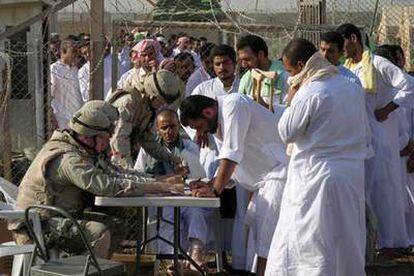 Detenidos iraquíes firman su salida de la cárcel de Abu Ghraib, en los alrededores de Bagdad.