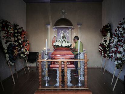 Un hombre junto al ataúd de Armando Pérez Luna, candidato panista asesinado en Michoacán.