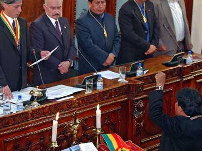 Evo Morales, frente a los miembros de la Mesa del Parlamento, jura su cargo con el puño izquierdo en alto.