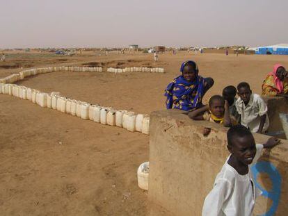 Varios ni&ntilde;os aguardan su turno ante uno de los pozos de agua potable del campo de refugiados de Abushok, en Darfur (Sud&aacute;n).