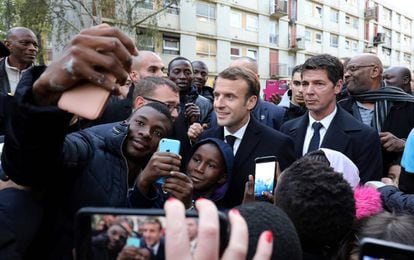 El presidente francés, Emmanuel Macron (c), se fotografía con residentes de Clichy-sous-Bois, a las afueras de Paris, este lunes.