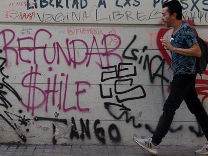 Un hombre camina frente a un mural pidiendo "Refundar Chile", el 27 de abril de 2023, en Santiago.