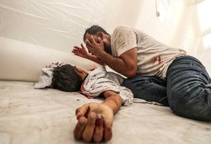 A man cries over the body of his dead son in Al-Shifa hospital, after an Israeli airstrike on Gaza launched on October 9.