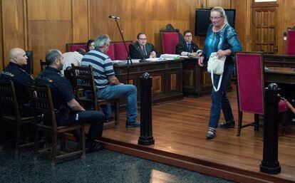 Margo Pool se cruza con los dos hermanos acusados (Juan Carlos y Julio, sentados ante dos policias) en la Audiencia de Ourense, al terminar de declarar durante la segunda sesión del juicio por la muerte de Martin Verfondern, en junio de 2018.