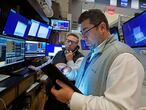 Traders Jonathan Mueller, left, and Michael Capolino work on the floor of the New York Stock Exchange, Monday, July 19, 2021. Stocks are falling sharply Monday as worries sweep from Wall Street to Sydney that the worsening pandemic in hotspots around the world will derail what's been a strong economic recovery. (AP Photo/Richard Drew)