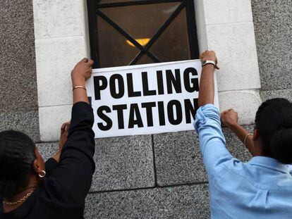 Trabajadores colocan carteles en un colegio electoral en Londres.
