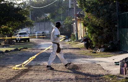 Un médico forense cerca con cinta policial el lugar donde fue asesinada una persona, en una imagen de archivo.