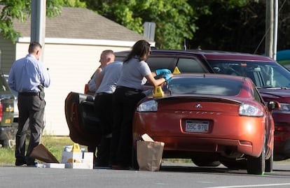 Police collect evidence from a car related to the confrontation between officers and the suspect, this Thursday, June 9.