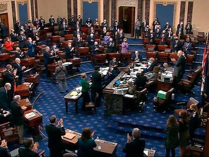Los senadores aplauden el resultado final de la votación del plan de rescate, este sábado en Washington.