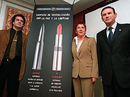 Urquijo, Lasa e Ibarretxe, ayer en Madrid ante el cartel de la campaña de apoyo a las víctimas de ETA.