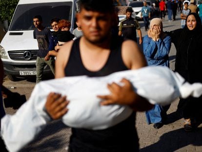 Un palestino llevaba el martes el cadáver amortajado de un niño muerto por un ataque israelí en Gaza.