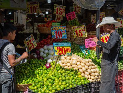 Vendedores atiende un puesto de verduras en el mercado de la Merced, en Ciudad de México.