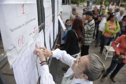 Una mujer comprueba la lista de votación en un colegio electoral en Caracas, Venezuela.