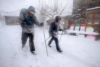 Dos personas caminan por la carretera nevada en O Cebreiro, Lugo.