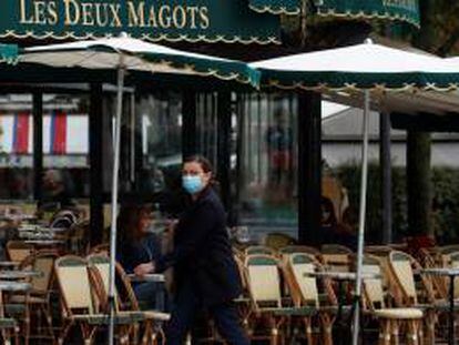 Una mujer pasa por delante del restaurante Les Deux Magots en Paris.