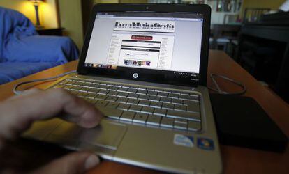 Una persona se baja contenidos de forma ilegal desde un portátil.