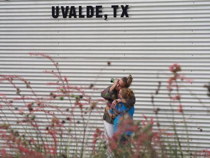 Una mujer lloraba y abrazaba a una niña mientras hablaba por teléfono el martes, en el exterior del Centro Cívico Willie de Leon, en Uvalde, Texas, tras el tiroteo que mató a 19 niños y dos profesoras en un colegio. El centro ofrece asistencia psicológica.