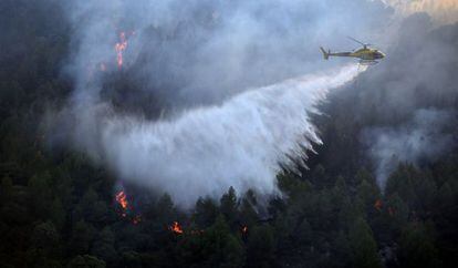 Un helicóptero intenta sofocar el incendio de Vilaverd, Tarragona.