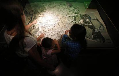 Los niños participantes en la ruta tocan con sus manos el mapa del Madrid medieval en el Museo de San Isidro.
