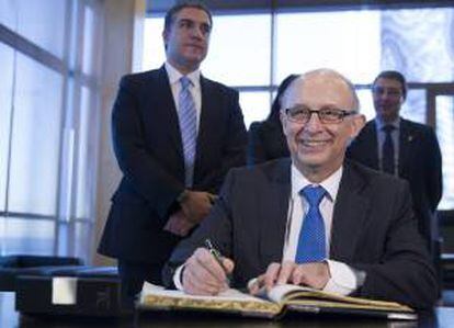 El ministro de Hacienda, Cristobal Montoro firma en el libro de autoridades durante su visita a la Diputación de Málaga.