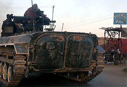 Dos soldados talibaes en un tanque ruso, a 50 kilómetros de Kabul.