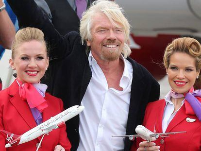 Richard Branson con dos azafatas de Virgin. 