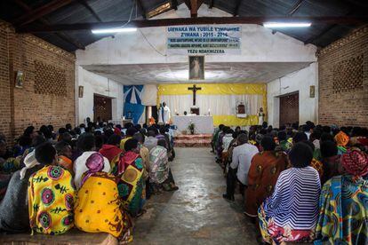Aldeanos asisten a una misa en el sector de Mutete, en Byumba (Ruanda) donde hace 25 años más de mil vidas, en su mayoría tutsi, fueron masacradas por genocidas Hutu. Pascal, de etnia hutu, y Jean-Bosco, tutsi, se juntan en la iglesia en la que se celebra la ceremonia religiosa en honor a la virgen María, el 29 de marzo de 2019, el primer sábado del mes. Son viejos amigos a quienes la vida separó y juntó más tarde.