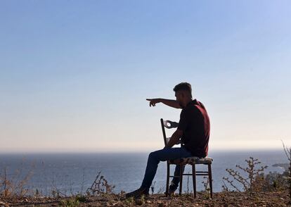 Un inmigrante señala hacia la Península Ibérica desde un asentamiento irregular en Ceuta en julio de 2021