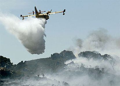 Un avión descarga líquido contra el fuego durante el incendio registrado ayer en Algeciras.