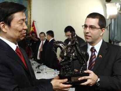 Fotografía cedida por prensa del Ministerio de Relaciones Exteriores de Venezuela donde se observa al vicepresidente de Venezuela Jorge Arreaza (d), entregando un obsequio al vicepresidente chino, Li Yuanchao (i).