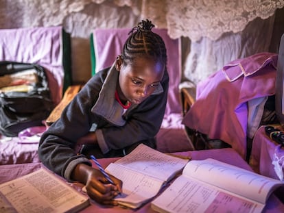 Sheila Achieng, una joven estudiante del asentamiento informal de Kibera, en Kenia, haciendo los deberes.