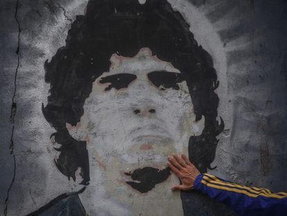Un fan de Boca Juniors pone su mano en un mural de Diego Armando Maradona tras su muerte, el pasado miércoles.