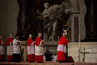 El cardenal Tarcisio Bertone besa un crucifijo en la bas&iacute;lica de San Pedro el viernes santo.