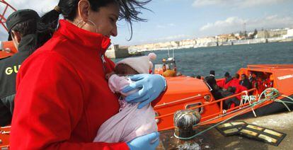 Una integrante de Cruz Roja sostiene a un bebé rescatado de una patera a principios de enero y trasladado a Tarifa.