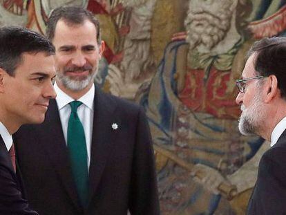 El nuevo presidente del Gobierno, Pedro S&aacute;nchez (izquierda) saluda a su antecesor, Mariano Rajoy, durante su toma de posesi&oacute;n ante el Rey (al fondo).