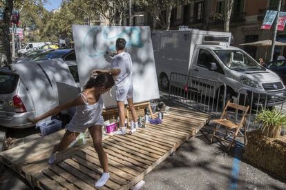 El 'Park(ing) Day' nació en San Francisco en 2005 de la mano de un colectivo de arquitectos que reivindicaban un modelo de ciudad "más verde y sin coches". En la imagen, dos niños juegan y pintan en uno de los aparcamientos habilitados en la calle Ronda de Sant Antoni.