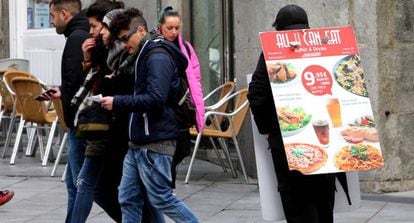 Una persona anuncia un restaurante en el centro de Madrid.
