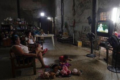 Una familia mira las noticias de la televisión local que muestra al expresidente Raúl Castro dirigiéndose a la audiencia de la sesión inaugural del Congreso del Partido Comunista de Cuba.