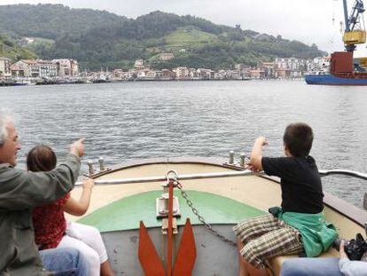 Una familia realiza un recorrido en barco por la aguas del puerto de Pasaia. 