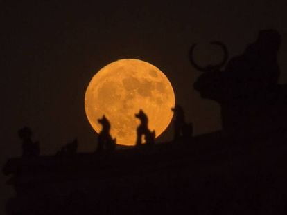 La Luna, vista tras las esculturas del tejado de la Ciudad Prohibida.