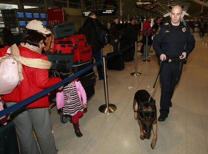 Un policía patrulla con un perro especializado en la detección de explosivos por el aeropuerto de Detroit.