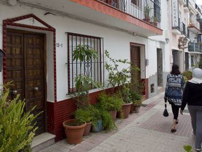 Dos mujeres caminan frente a la casa del menor fallecido. 