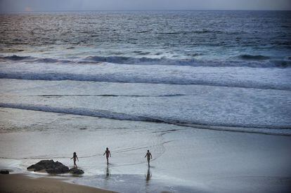 Varios nudistas caminan por la playa de Mar de Fora, en Finisterre (Galicia).