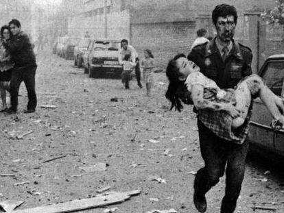 Un guardia civil lleva a una ni&ntilde;a tras el atentado contra la casa cuartel de Vic en 1991.